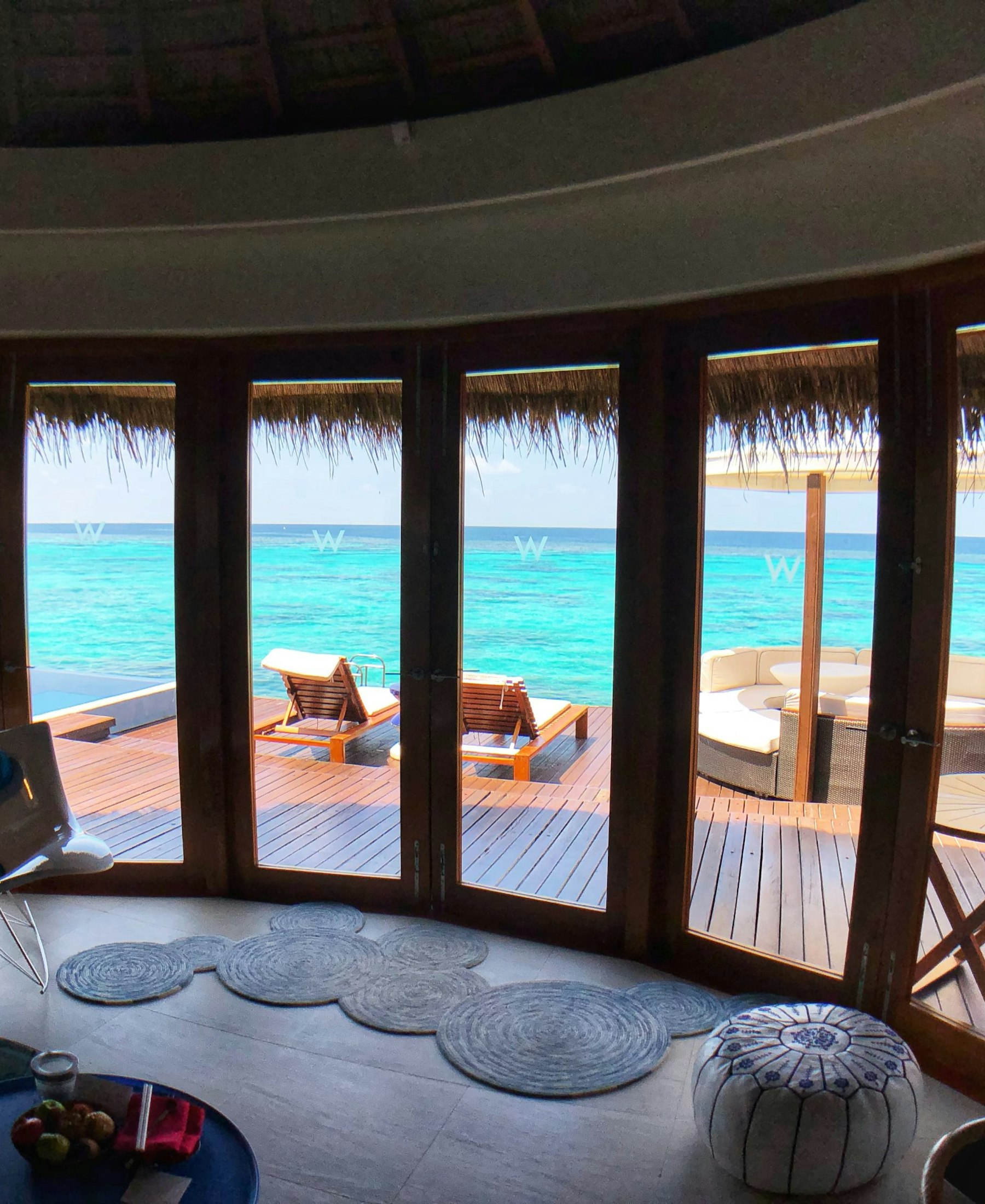 A wooden overwater deck looking out over pale turquoise lagoon