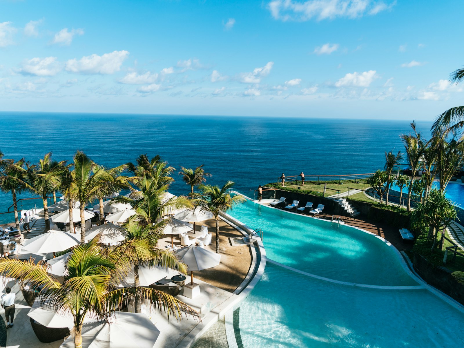 An infinity pool looking out to a tropical bay at dusk